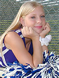 cute blonde cheerleader in shiny pantyhose posing outdoors